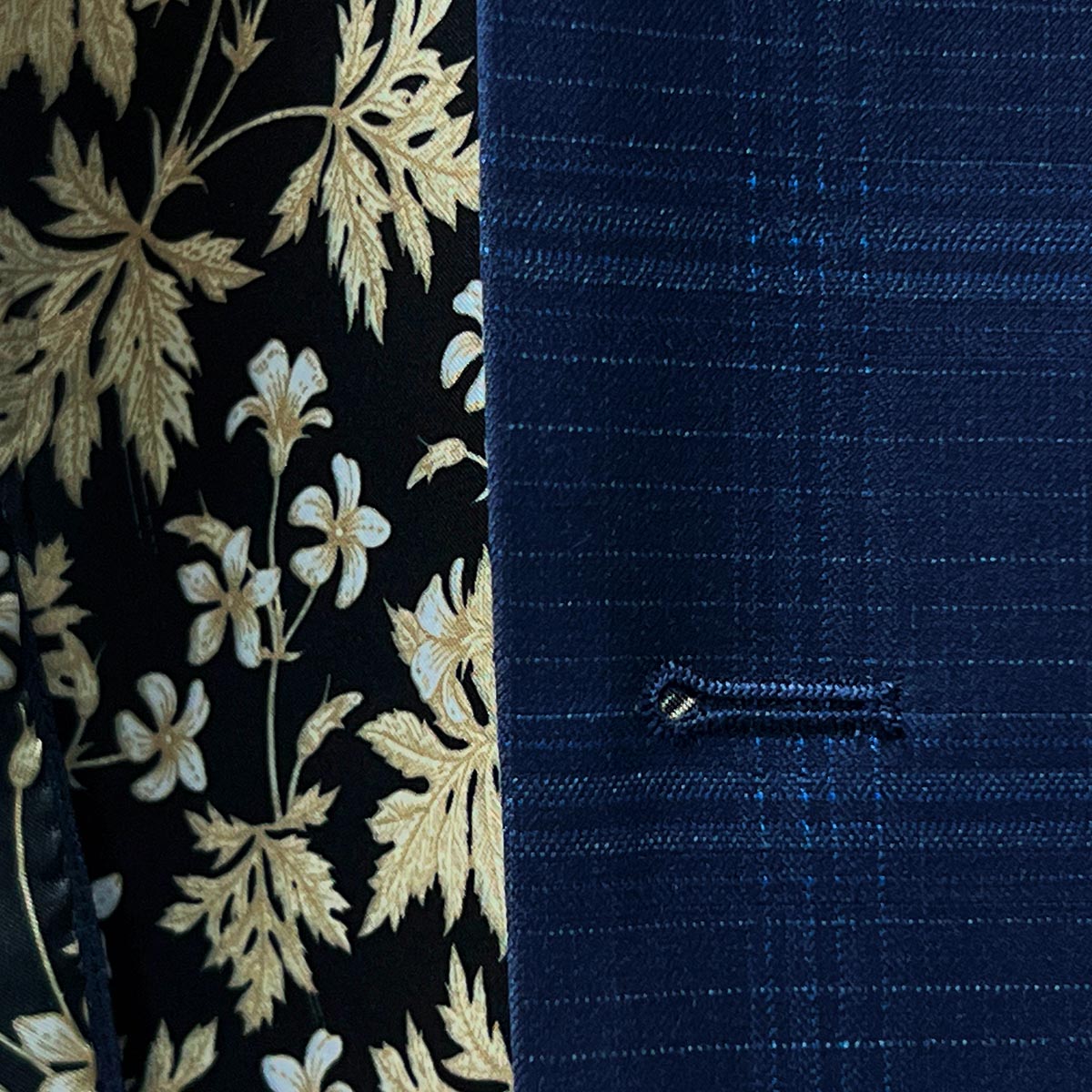 buttonholes adding a distinctive flair to a midnight blue windowpane suit.