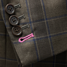 Close-up view of the contrast pink accent buttonholes on a chocolate brown sportcoat.