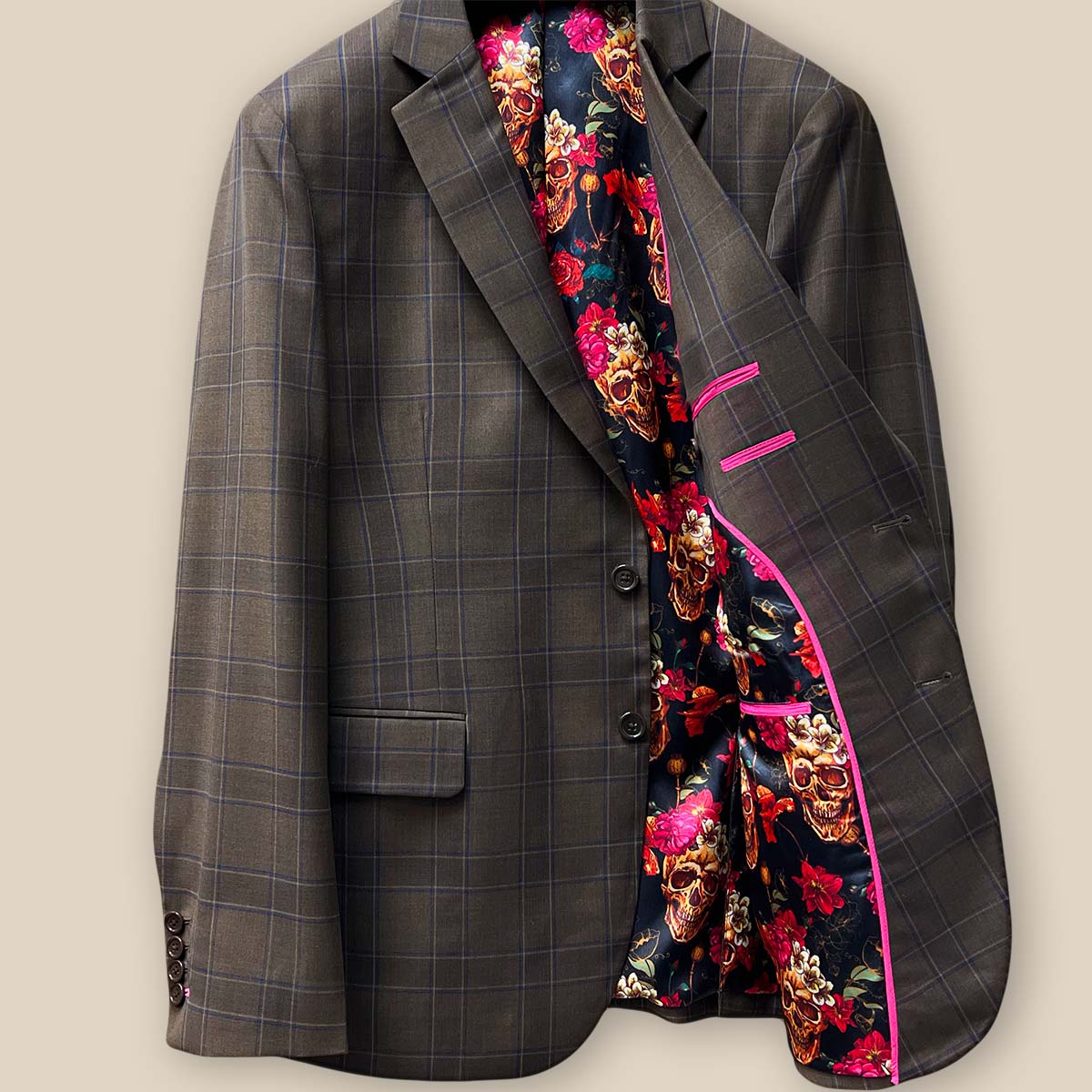 Interior view of the left side of a chocolate brown sportcoat, featuring fuchsia pink contrast trimming.