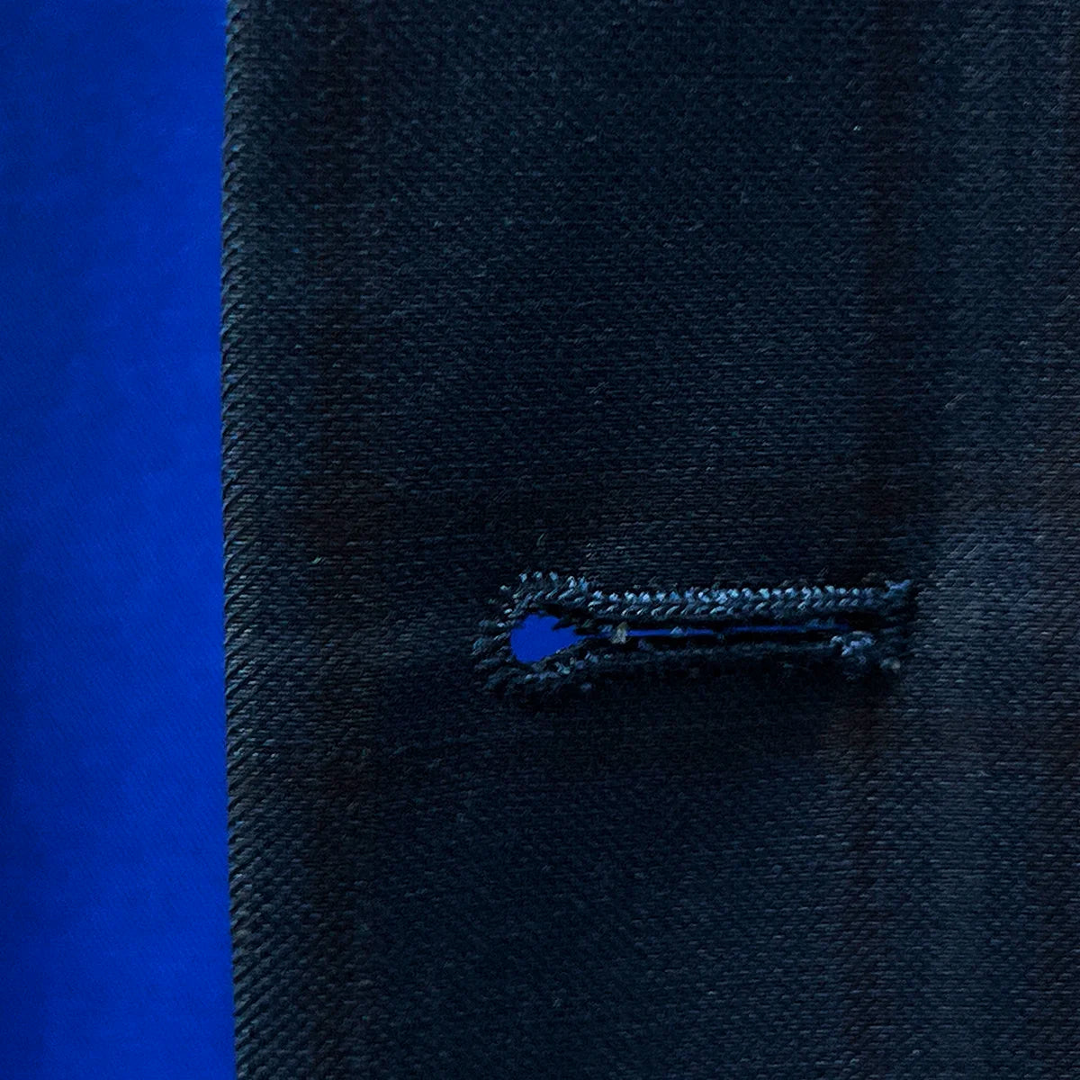 Close-up image showcasing the maroon buttonhole stitching on the sportcoat.