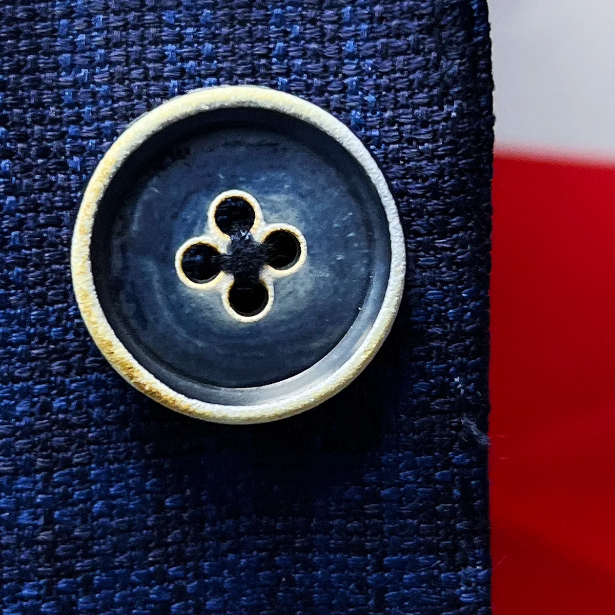 Detailed view of the distinctive blue bone buttons with white trim, showcasing their natural variation and premium quality