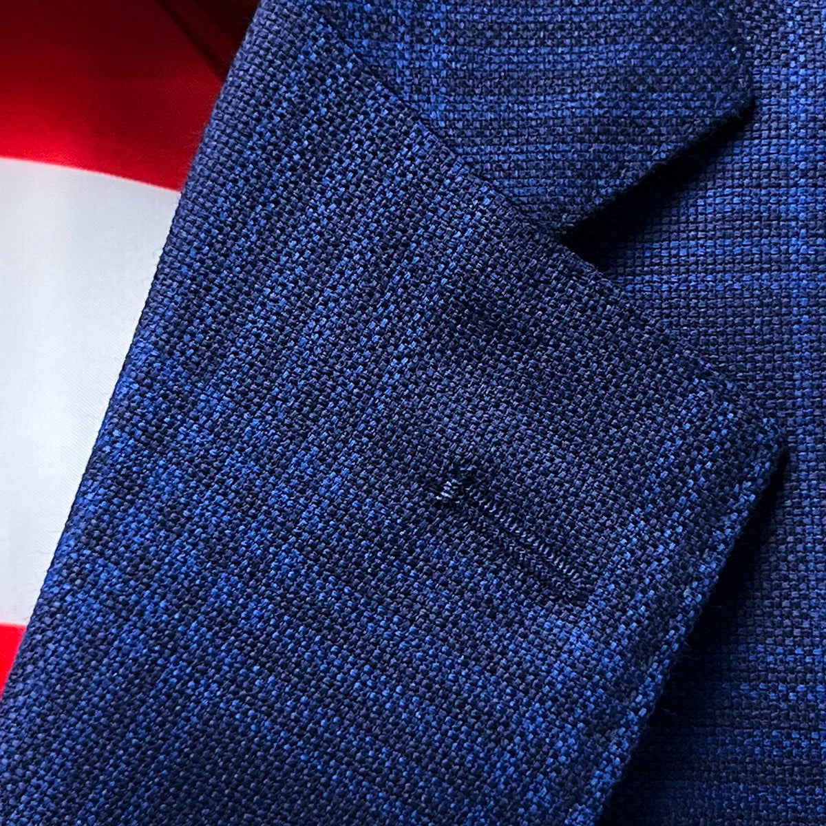 Detail of the classic notch lapel with precise hand pick stitching on the premium blue windowpane Zegna wool-silk fabric