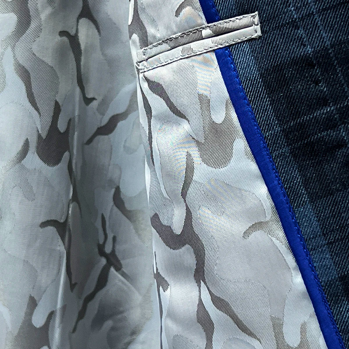 View of the camouflage grey flash lining inside a Prussian Blue sportcoat with black grid checks.