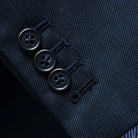 Close-up of working sleeve buttonholes with black accent stitching on navy wool