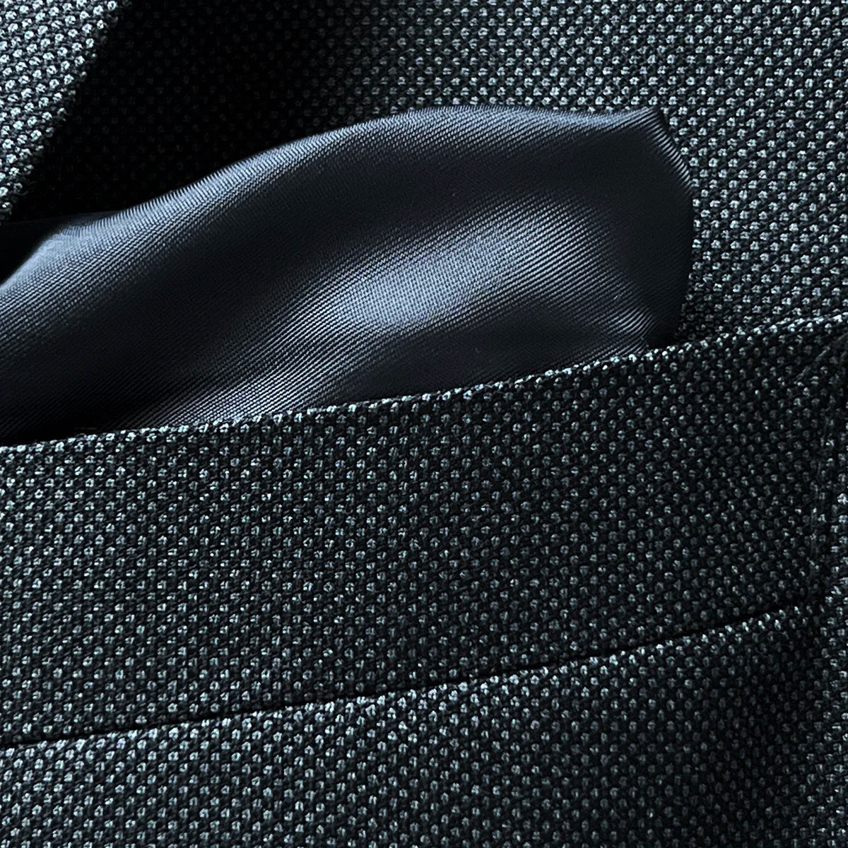 Detail of jacket breast pocket showcasing the birdseye pattern and pocket construction