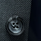 Macro shot of dark grey horn buttons showing natural marble-like patterns