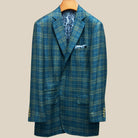 Close-up view of deep teal green multi check suit jacket showing contrast olive green accent buttonhole with hand-finished stitching detail