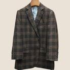 Front button panel of brown rust block windowpane sport coat featuring walnut dark brown and amber horn buttons