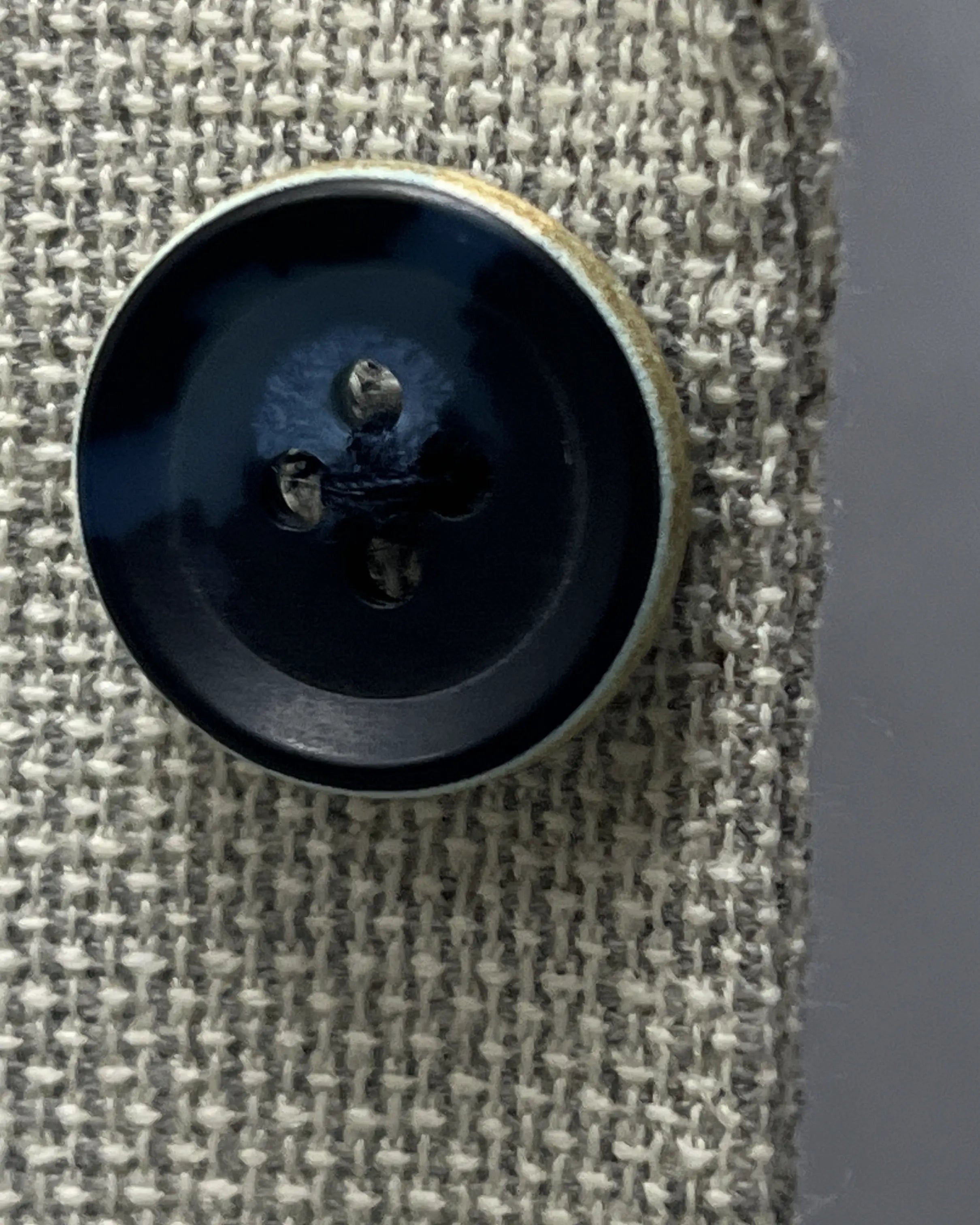Button detail of light tan hopsack men's sport coat showing dark navy horn buttons