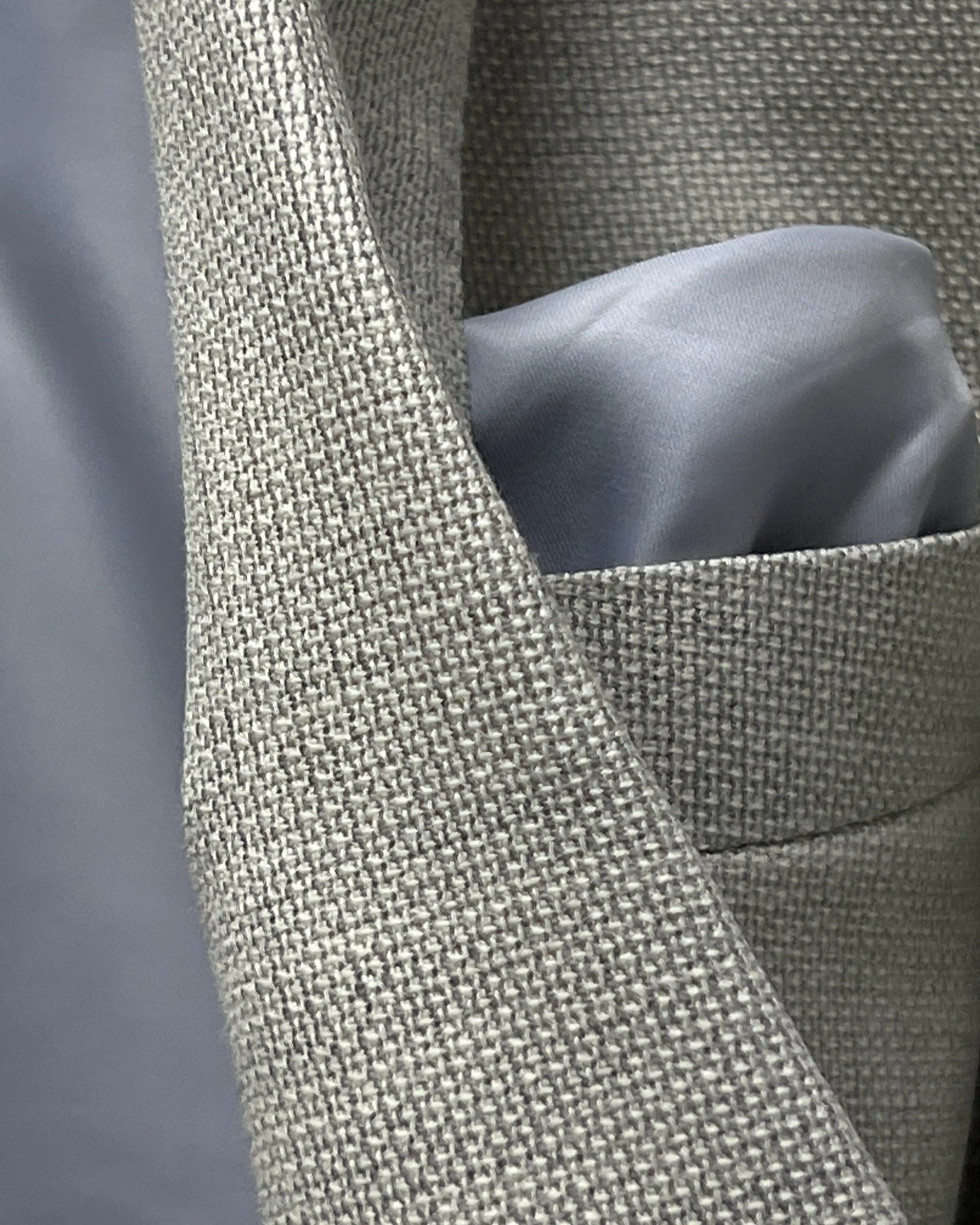 Fabric close up of light tan hopsack men's sport coat showing open hopsack texture and dry basket weave