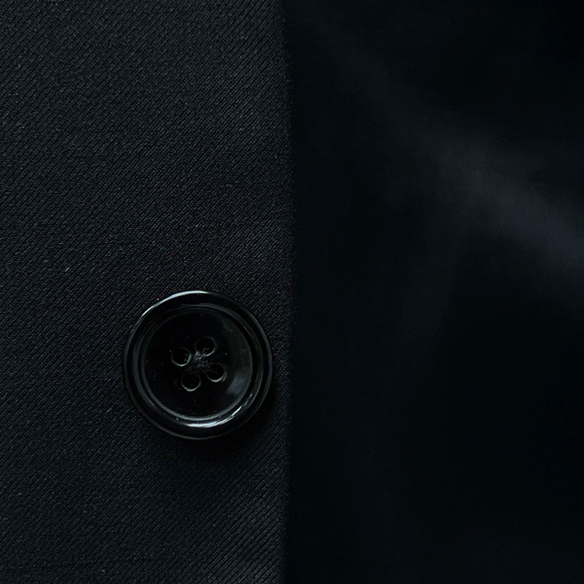 Horn buttons enhancing the traditional elegance of a classic black men's suit.