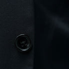 Horn buttons enhancing the traditional elegance of a classic black men's suit.