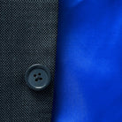 Elegant horn buttons enhancing the sophisticated look of a dark grey birdseye suit.