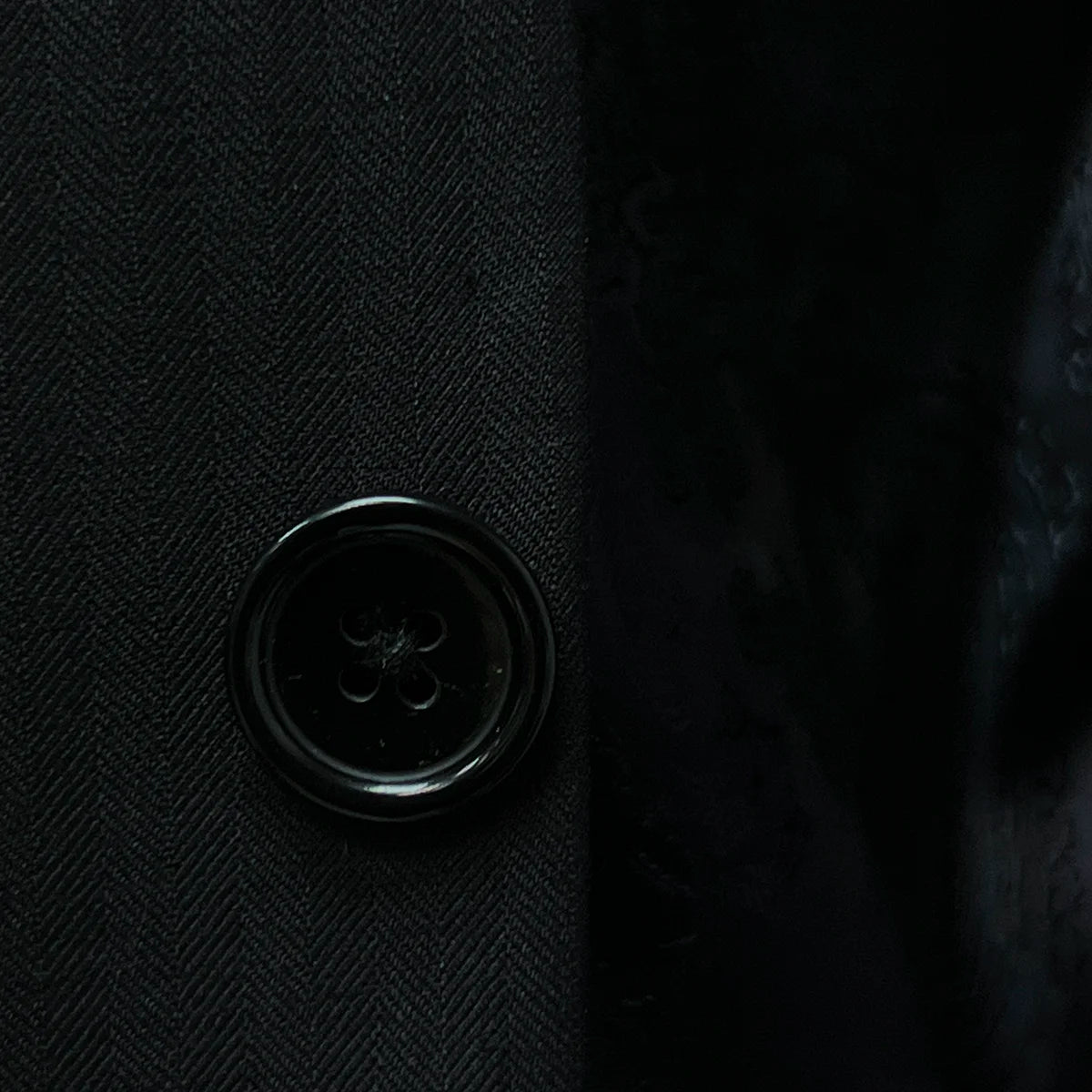 Elegant horn marble buttons on a black herringbone suit.