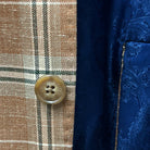 Horn marble buttons adding a classic touch to a brown beige men's sport coat with blanched almond and midnight blue windowpane pattern.