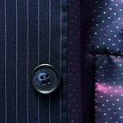 Horn marble buttons enhancing the refined look of a navy suit with purple pinstripes.