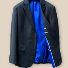 Inside view of the left side of the jacket showcasing the lining quality of a dark grey birdseye suit.