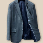 Inside view of the jacket showcasing the lining and construction of a dark grey nailhead suit.