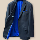 Inside view of the right side of the jacket revealing the interior finish of a dark grey birdseye suit.
