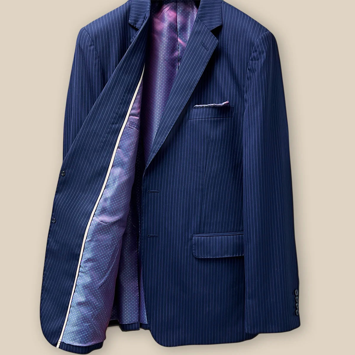 Inside right view of a navy suit with purple pinstripes, showcasing the inner lining and construction.