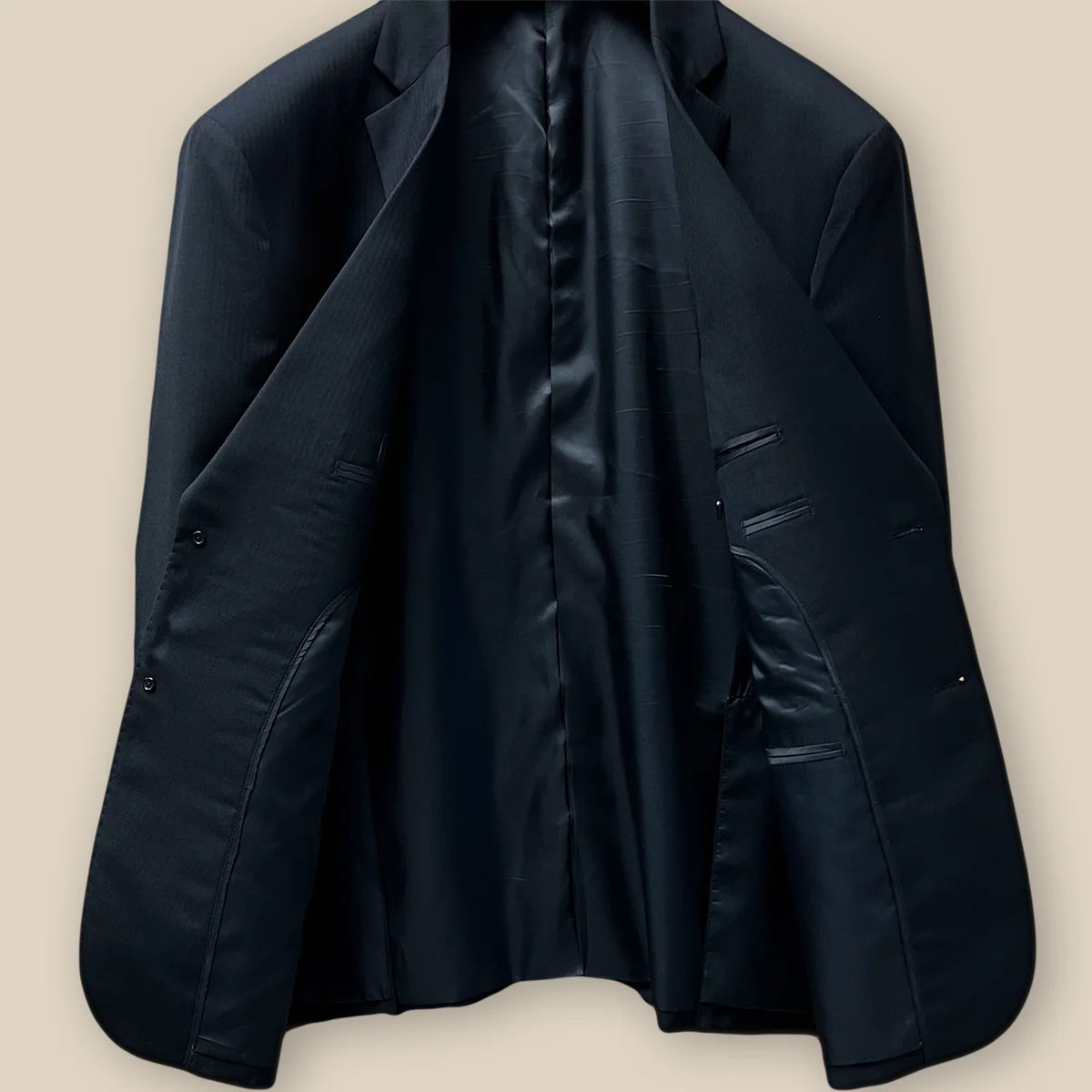 Comprehensive inside view of a black herringbone jacket's craftsmanship.