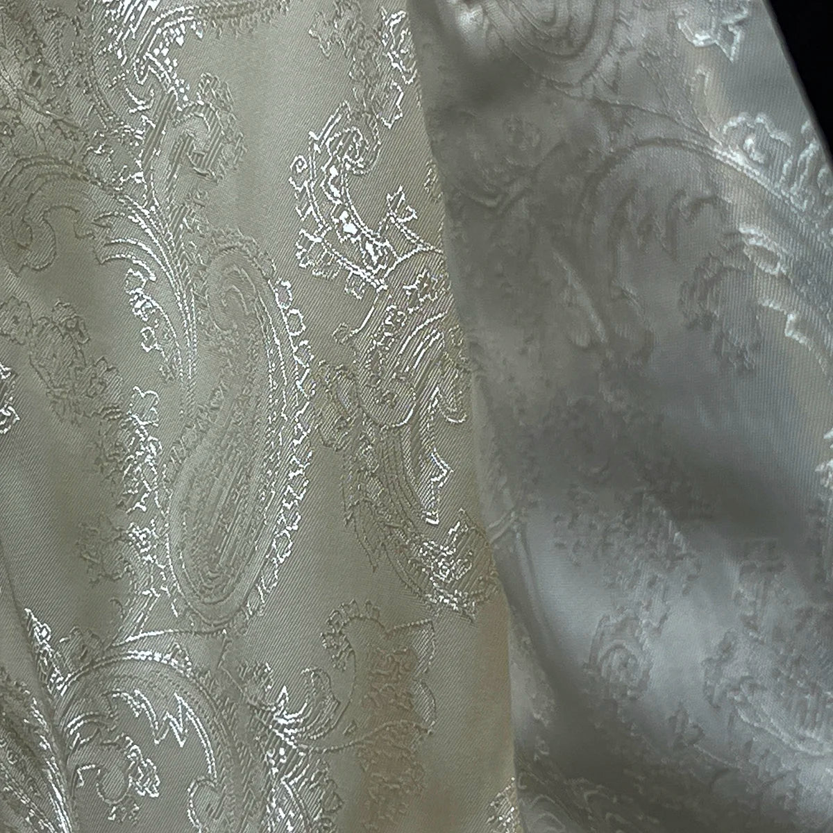 Detailed view of the off white paisley Bemberg lining inside the ivory tuxedo jacket, highlighting the quality fabric.