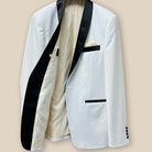 Inside view of the right side of the ivory tuxedo jacket with off white paisley lining and interior details.