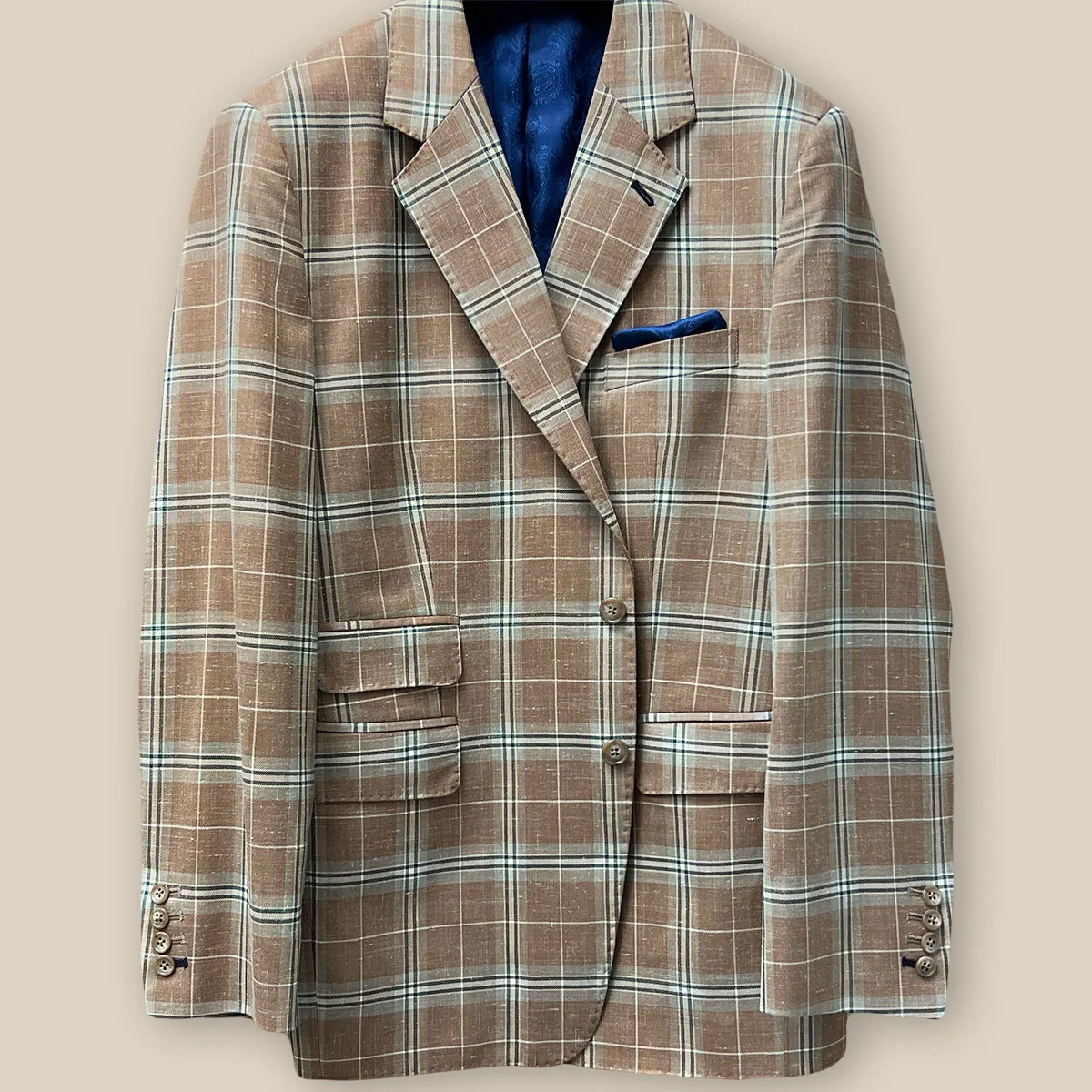 Button panel view detailing on a brown beige men's sport coat with blanched almond and midnight blue windowpane pattern.