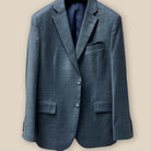 The button panel view of a jacket illustrating the fastening system of a dark grey nailhead suit.