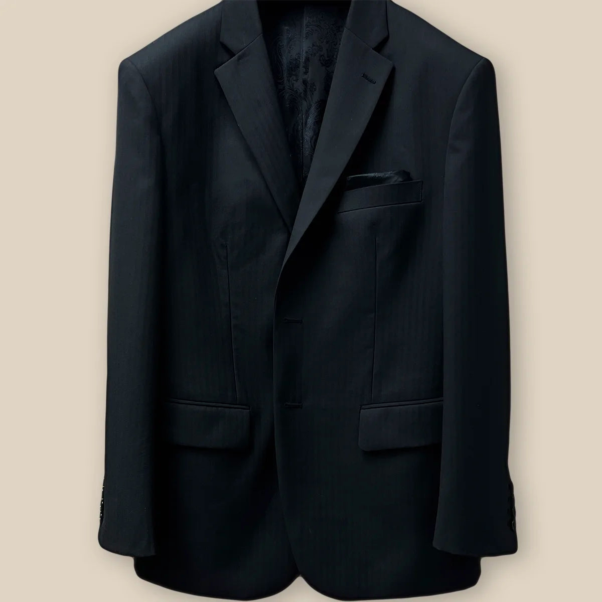 Buttonhole panel of a black herringbone men's suit.
