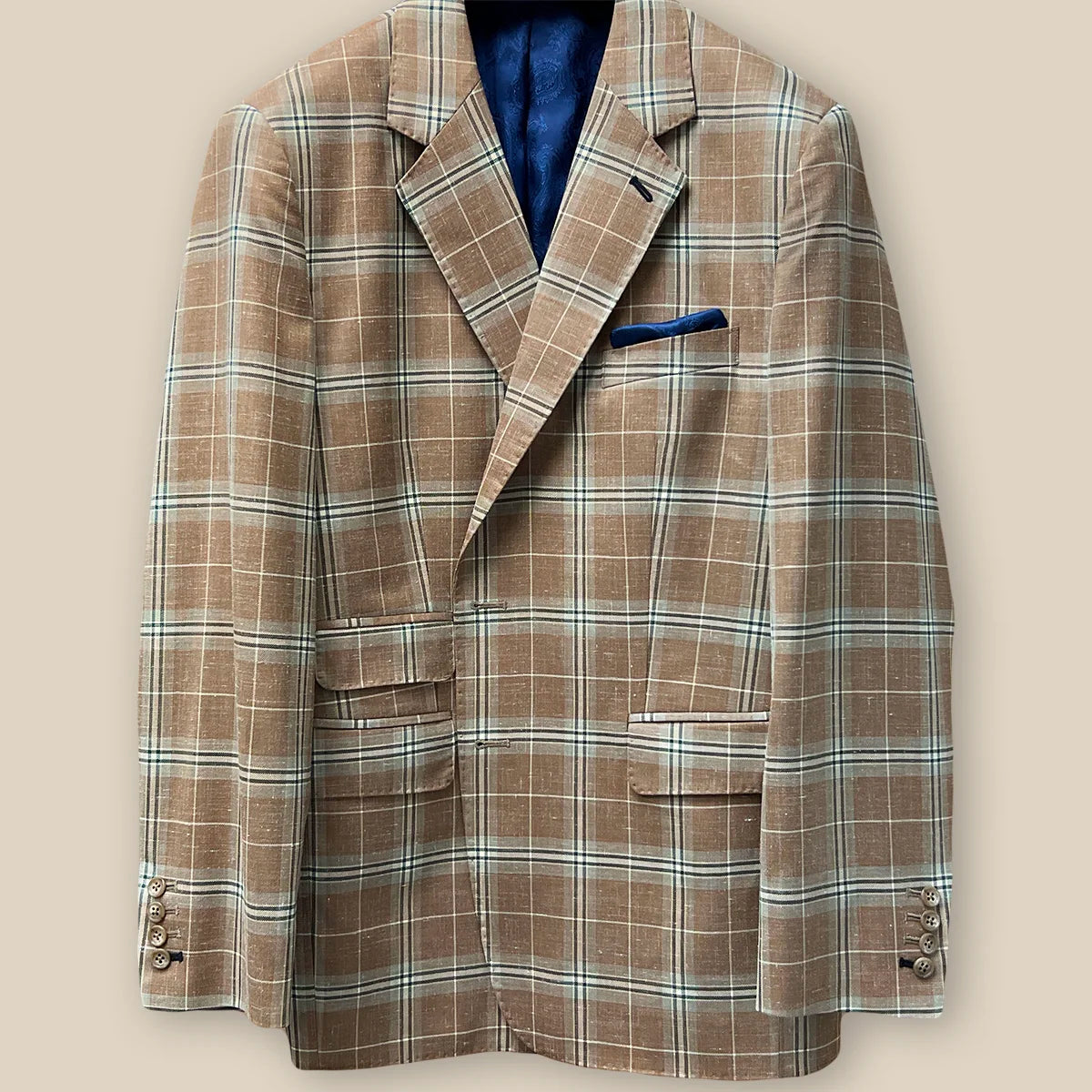 Buttonhole panel view on a brown beige men's sport coat with blanched almond and midnight blue windowpane pattern.