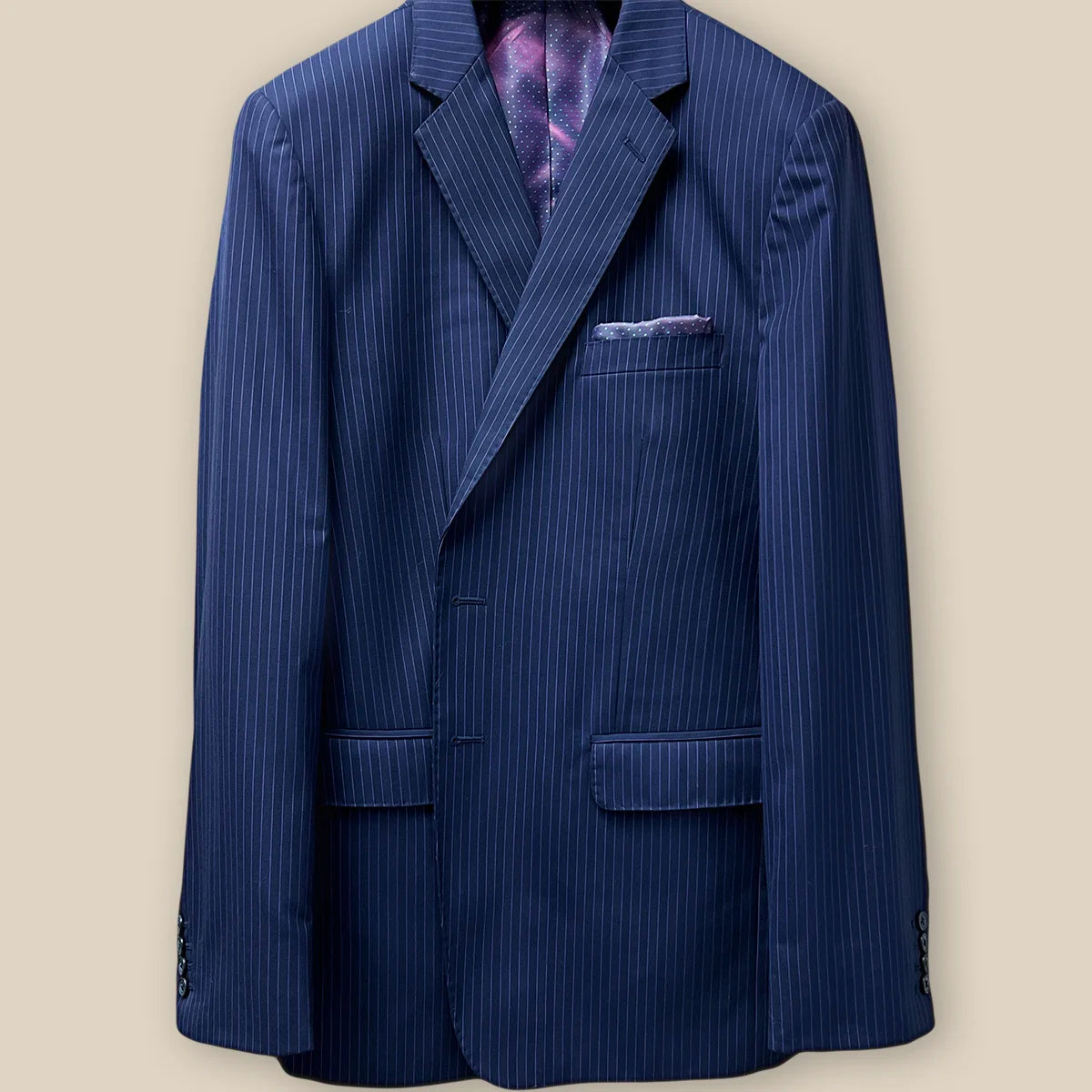 Buttonhole panel view of a navy suit with purple pinstripes, showcasing the detailed craftsmanship.