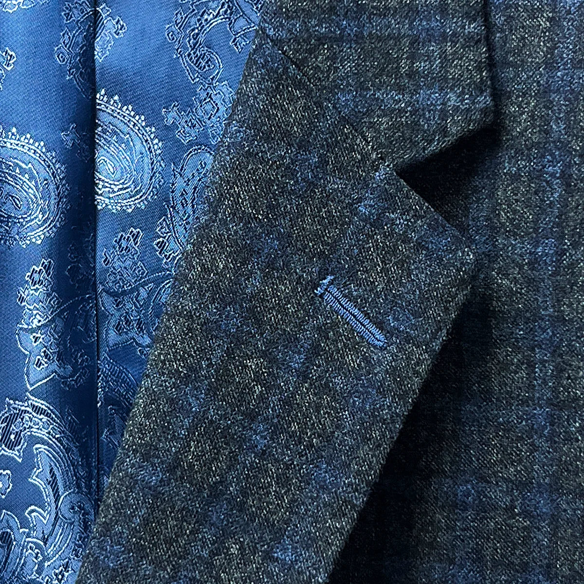 Lapel buttonhole detail on a grey blue grid check flannel sportcoat.