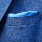 Close-up of light blue solid Irish linen men's suit jacket breast pocket with built-in pocket square detail