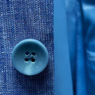 Macro shot of blue horn marble buttons used on the light blue solid Irish linen men's suit