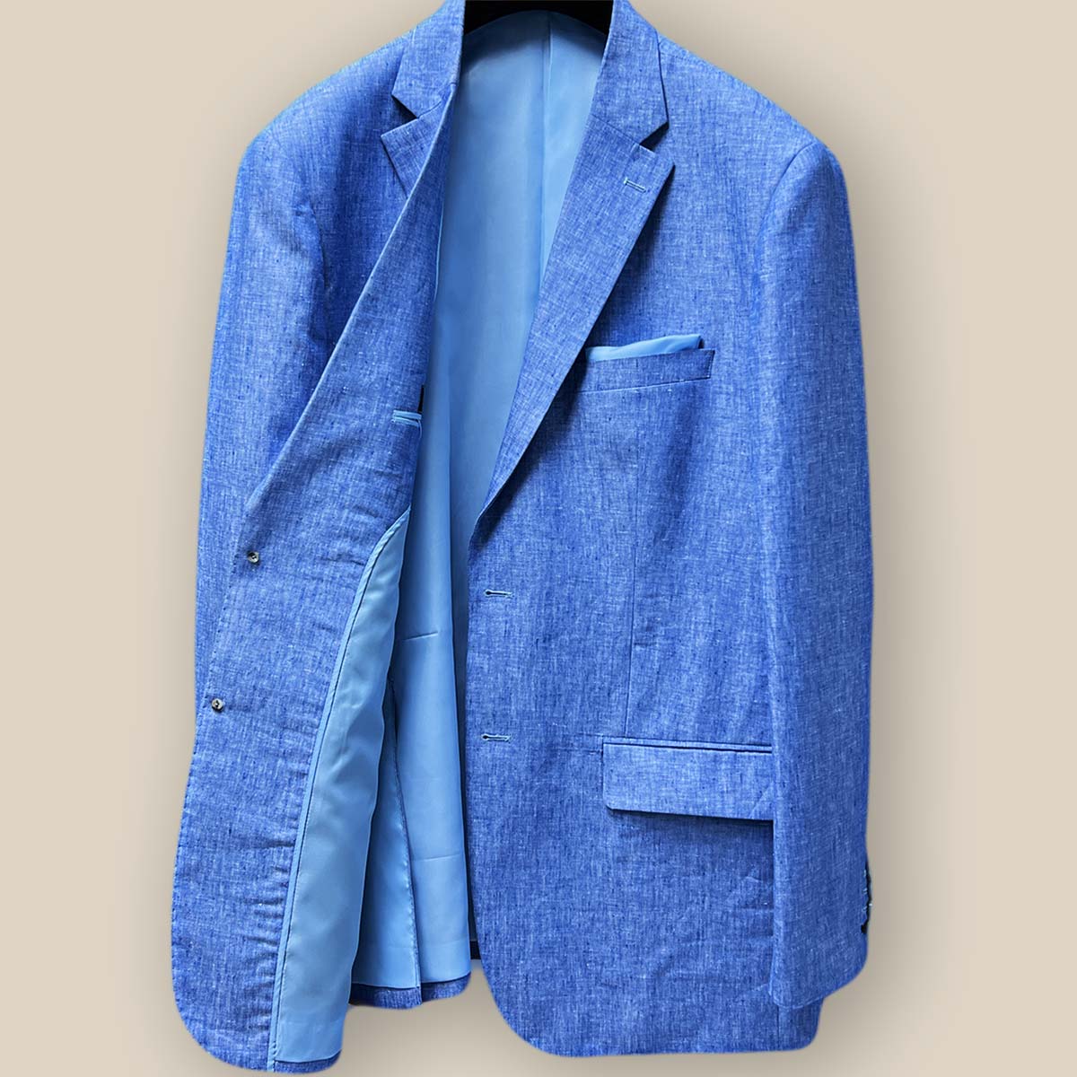 Interior view of light blue solid Irish linen men's suit jacket, showcasing sky blue bemberg silk lining on the left side