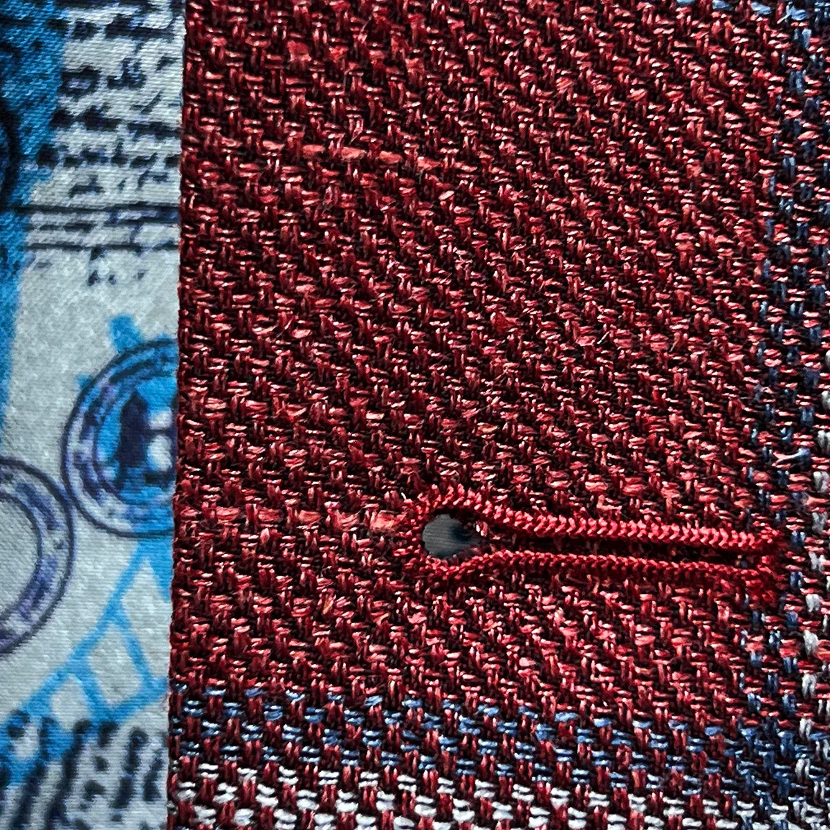 Macro shot of precise hand-stitched buttonhole detailing in sky blue thread