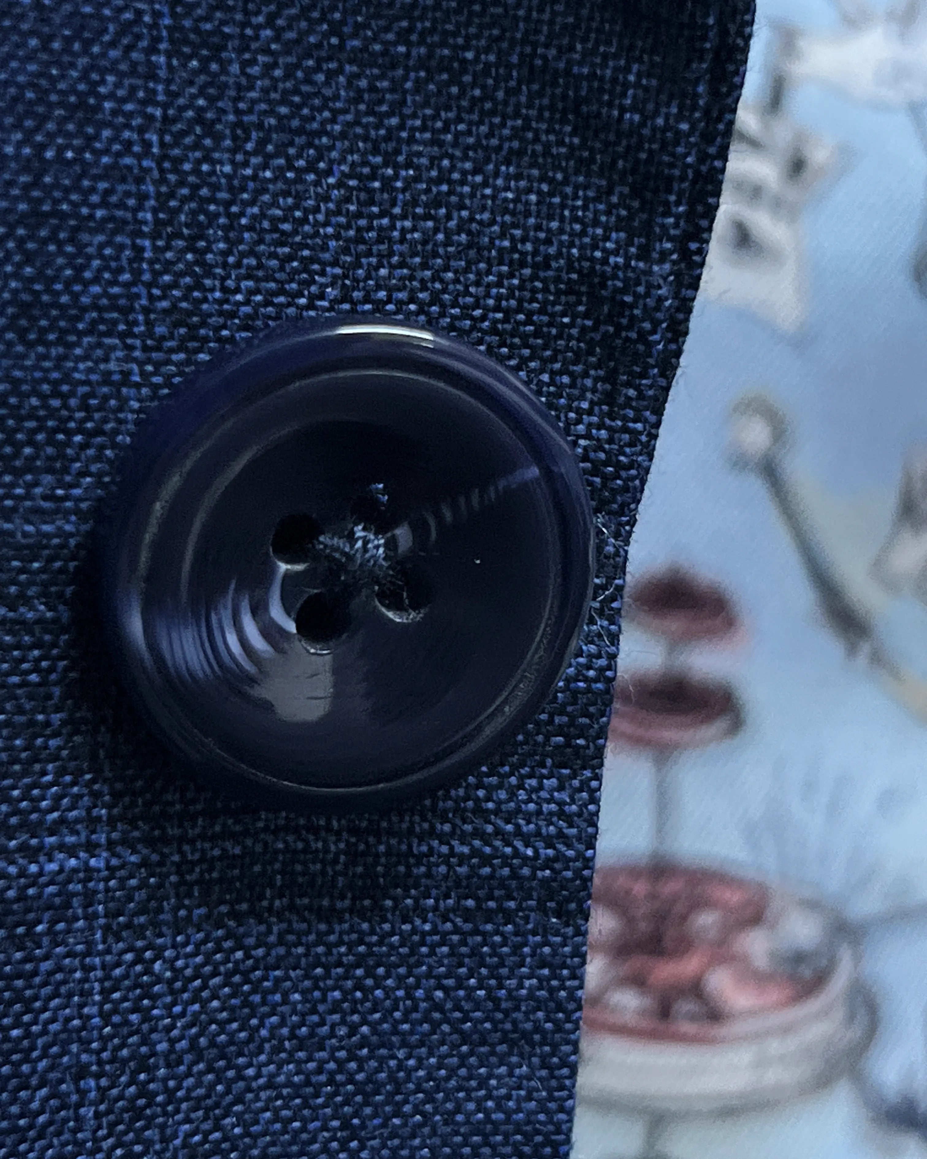 Button close up of blue windowpane check men's suit showing dark navy horn buttons
