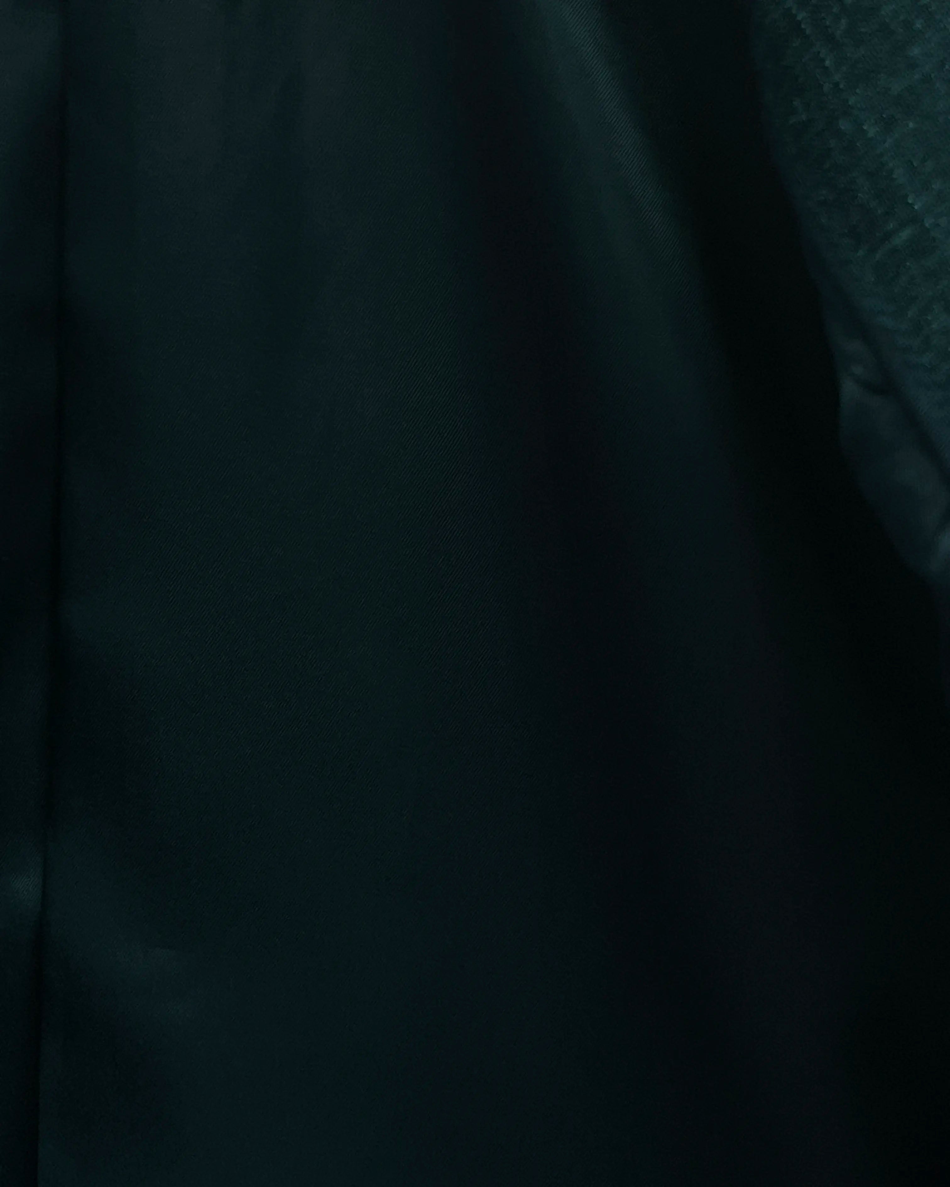 Lining detail image of deep green solid men's suit showing green cupro bemberg lining