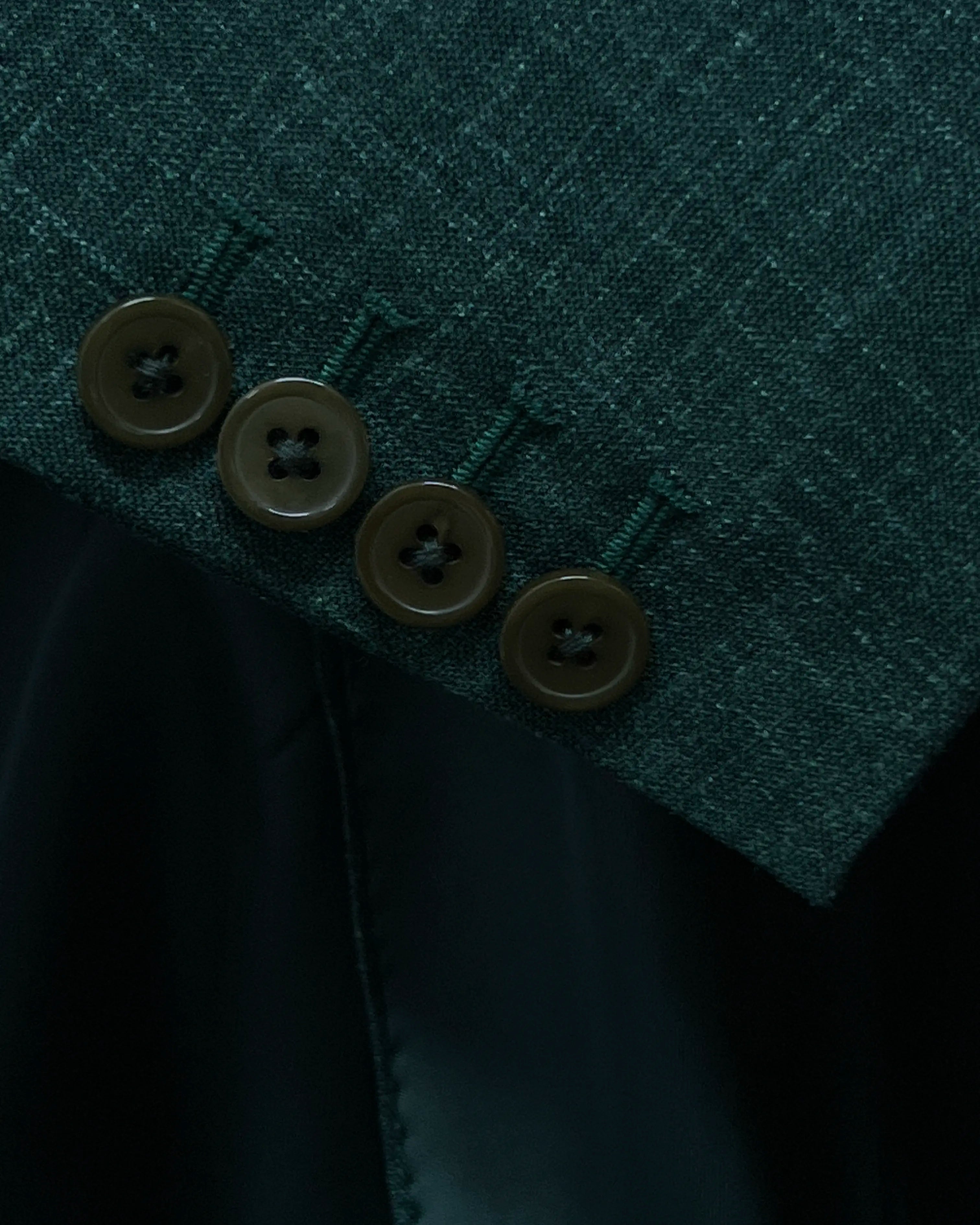 Sleeve detail image of deep green solid men's suit showing functional sleeve buttons and standard sleeve buttonholes