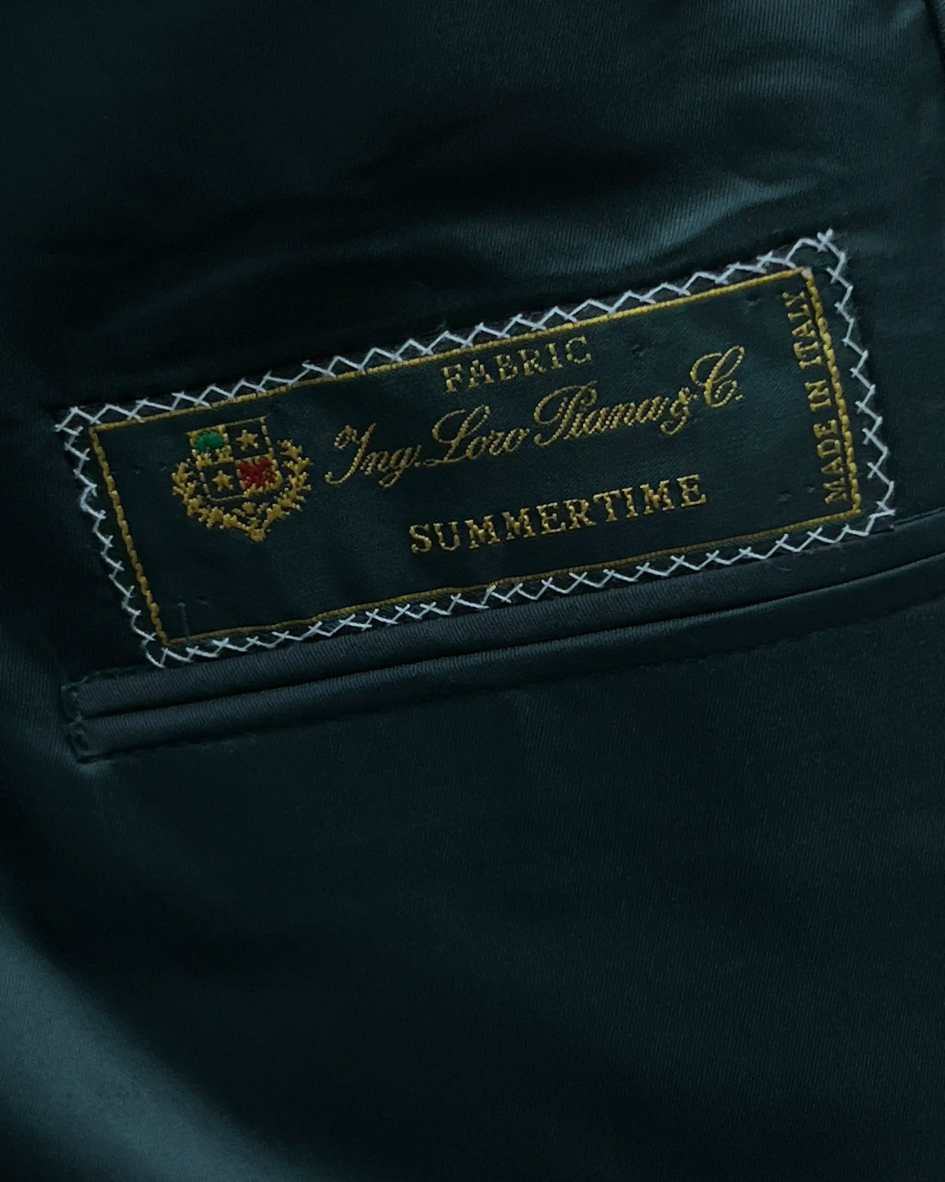 Mill label detail image of deep green solid men's suit showing Loro Piana fabric identity