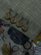 Sleeve cuff of sage green plain men's suit showing four functional surgeon's buttonholes