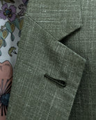 Macro close-up of Milanese lapel buttonhole on sage green plain men's suit showing raised cord detail