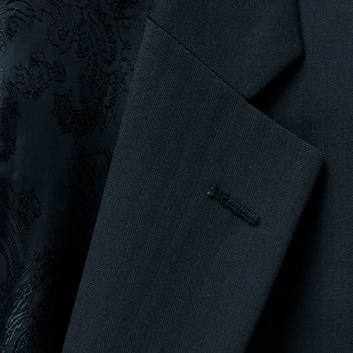 Classic notch lapel on a black herringbone men's suit.
