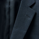 Notch lapel presenting a classic silhouette on a dark gray sharkskin suit.