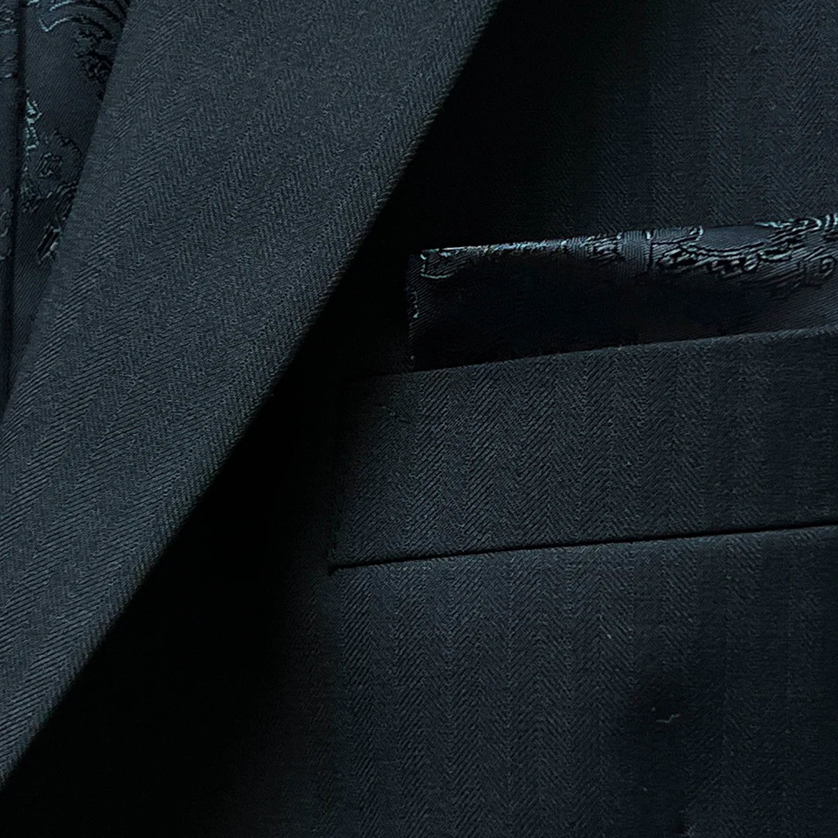 Pocket square in a classic black herringbone men's suit.