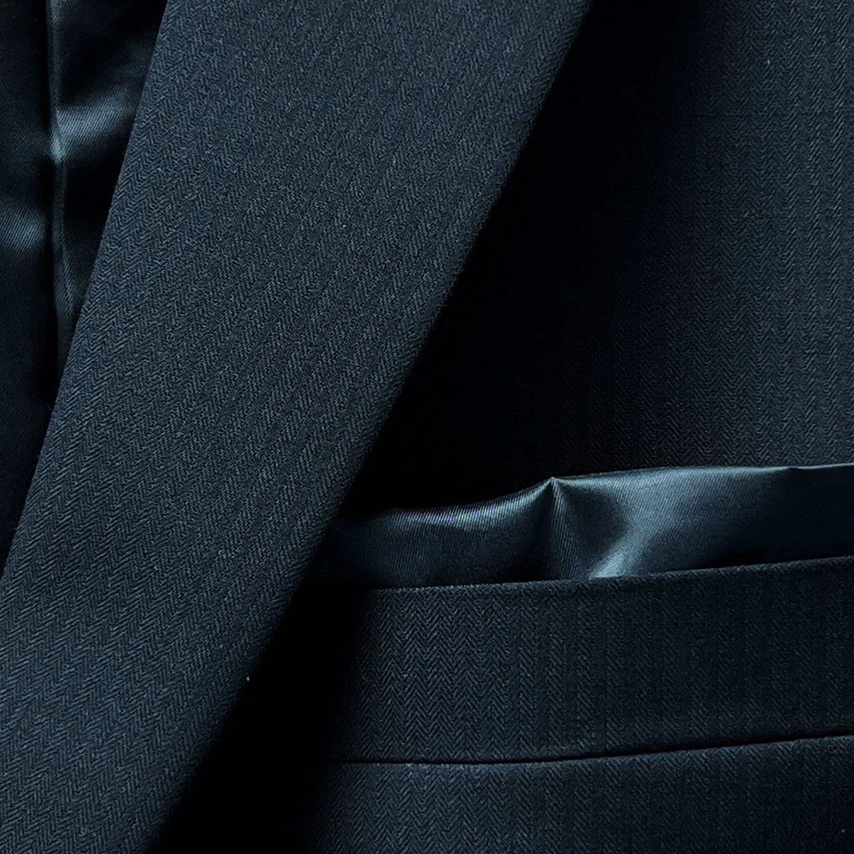Stylish pocket square complementing a black herringbone blazer.