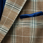 Pocket square adding elegance to a brown beige men's sport coat with blanched almond and midnight blue windowpane pattern.