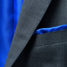 A stylish pocket square adding a dash of elegance to a dark grey birdseye suit.