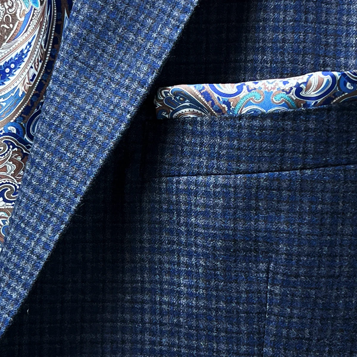 Pocket square adding a sophisticated touch to a gray blue mini grid checks sport coat made of flannel wool.
